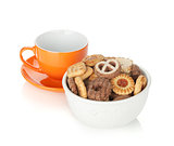 Various cookies in bowl and orange tea cup