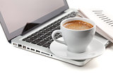 Hot cappuccino cup on laptop and newspaper