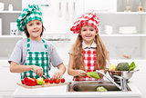Kids helping in the kitchen - washing and slicing vegetables