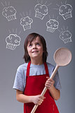 Young chef with apron and large wooden spoon