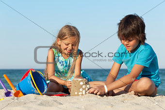 Kids playing on the beach building sand castle