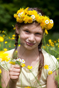 Girl with flowers in her hair on a meadow