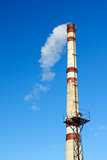 Smoke from a factory chimney against blue sky