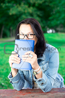 Beautiful young woman with book in park