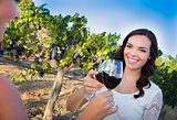 Young Woman Enjoying Glass of Wine in Vineyard With Friends