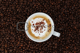cappucino in cup on coffee beans