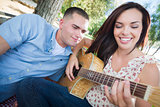 Mixed Race Couple at the Park Playing Guitar and Singing
