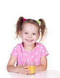 Cute little girl is drinking orange juice