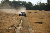Tractor and baler in a field at harvest time