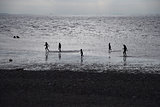 Children playing at the beach in silhouette