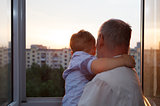 Grandfather and grandson embracing on the balcony