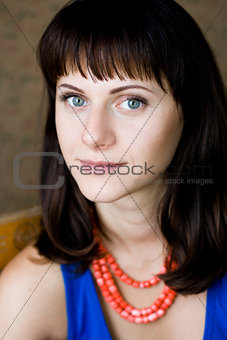 Portrait of a beautiful young brunette with red beadsPortrait of a beautiful young brunette with red beads