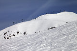 Off-piste slope and ropeway against blue sky