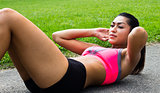 Fit young woman doing sit-ups outdoors