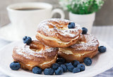 Cream puffs or choux pastry rings with blueberries on the plate
