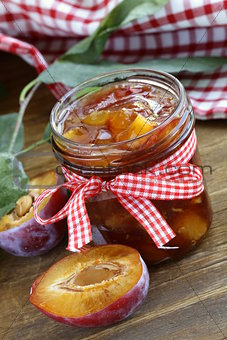 Plum jam in  jar on  wooden table
