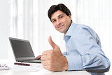 Businessman showing his thumb up in office
