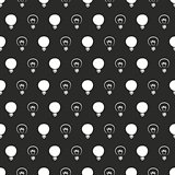 Seamless dark vector pattern or texture with light bulbs on black background.