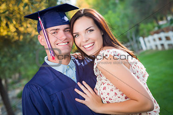 Male Graduate in Cap and Gown and Girl Celebrate