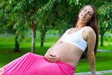 Pregnant woman sitting and relaxing in a park