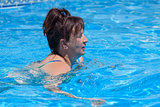 Middle-aged woman swims in the swimming pool