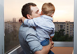 Father kisses his son on the balcony