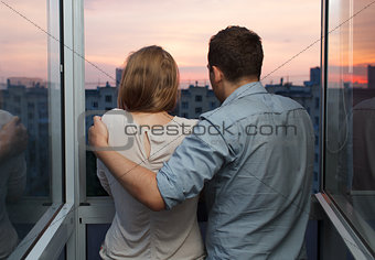 Young couple on the balcony watching sunset