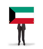 Businessman holding a big card, flag of Kuwait
