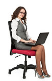 Business brunette girl on a chair with a laptop