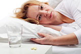 Taking pills - woman laying in bed