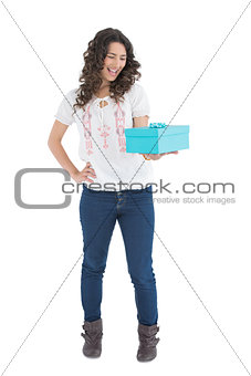 Cheerful casual brunette holding a present