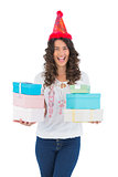 Cheerful casual brunette with party hat holding presents
