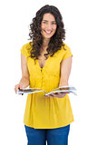 Cheerful curly haired brunette reading magazine