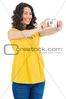 Curly haired brunette taking picture of herself