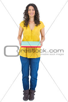 Smiling curly haired brunette holding notebooks