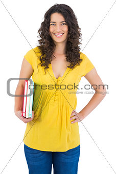 Happy curly haired student holding notebooks
