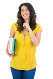 Cheerful curly haired student holding notebooks