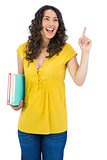 Happy curly haired student holding notebooks