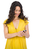 Smiling casual young woman texting on her phone