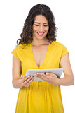 Smiling casual young woman using her tablet computer
