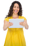 Smiling casual young woman holding her tablet computer