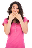 Surprised brown haired woman hiding her mouth