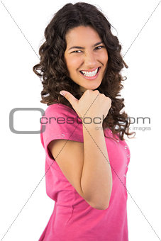 Smiling dark haired model posing thumb up