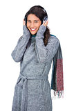 Smiling beautiful model wearing winter clothes listening to music