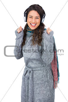 Gorgeous model with winter clothes dancing while listening to music