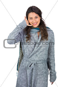 Cheerful model with winter clothes making phone call gesture
