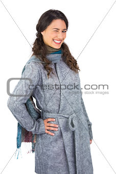 Smiling model with winter clothes winking at camera