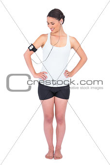 Smiling slender model wearing armband holding mp3 player
