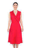 Cheerful elegant brunette in red dress posing