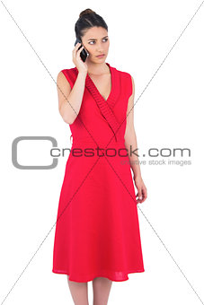 Elegant brunette in red dress on the phone posing